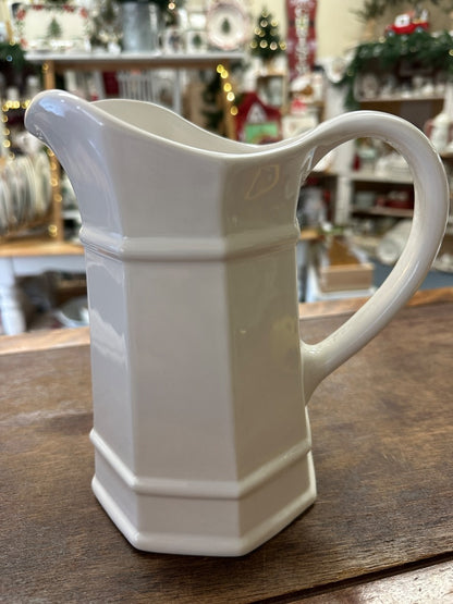White ceramic pitcher with wide spout and curved handle, front view