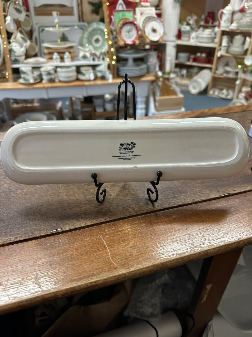 White oval holiday tray with two black display hooks, underside view
