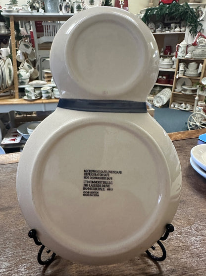 Snowman-shaped ceramic plate back with printed safety text on metal stand