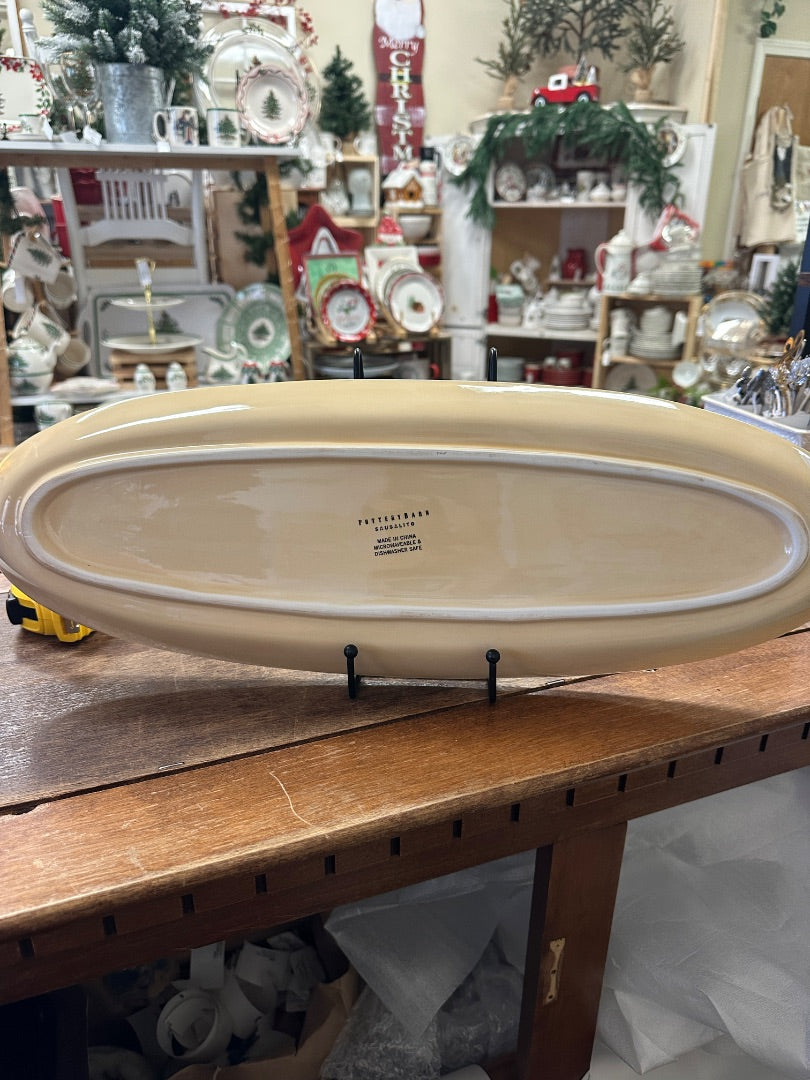 Yellow oval serving platter underside with care and maker text
