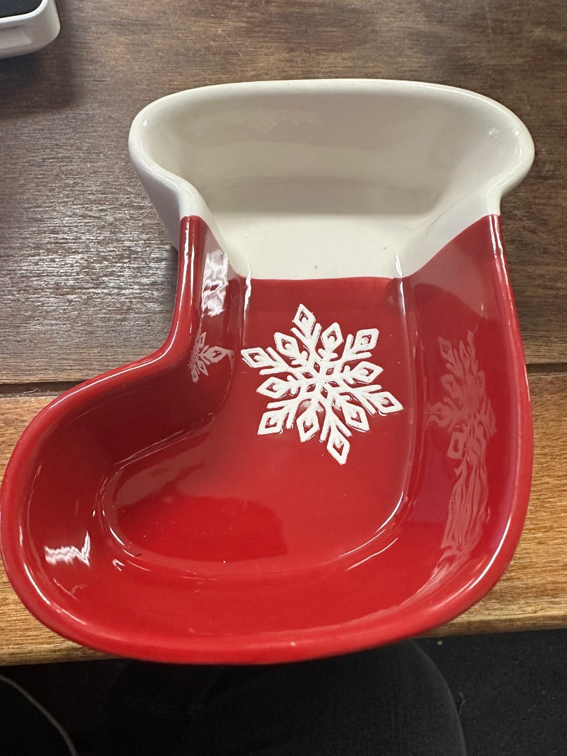 Red and white ceramic stocking-shaped bowl with snowflake logo on front