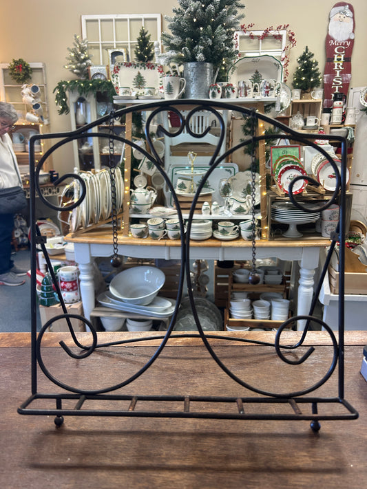 Black metal cookbook stand with curved scroll frame and wire page rest base