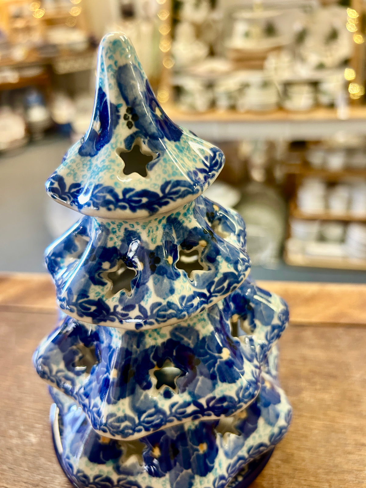 Blue ceramic tree luminary with speckled glaze, scalloped tiers, and leafy cutouts