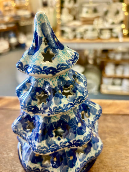Blue ceramic tree luminary with speckled glaze, scalloped tiers, and leafy cutouts