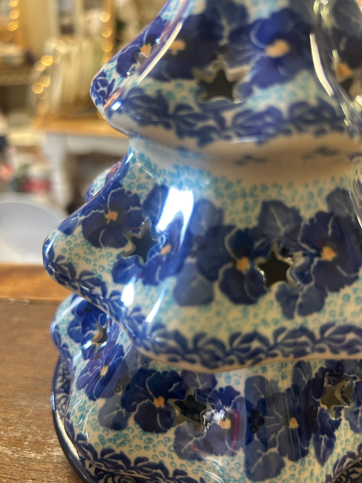 Close-up of blue ceramic tree luminary with floral pattern and scalloped tiers