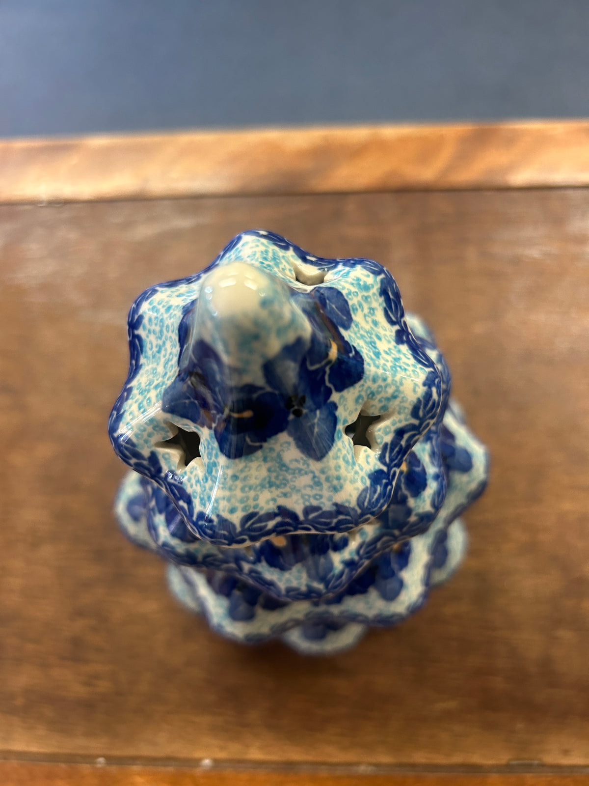 Blue ceramic tree luminary viewed from above with scalloped top opening