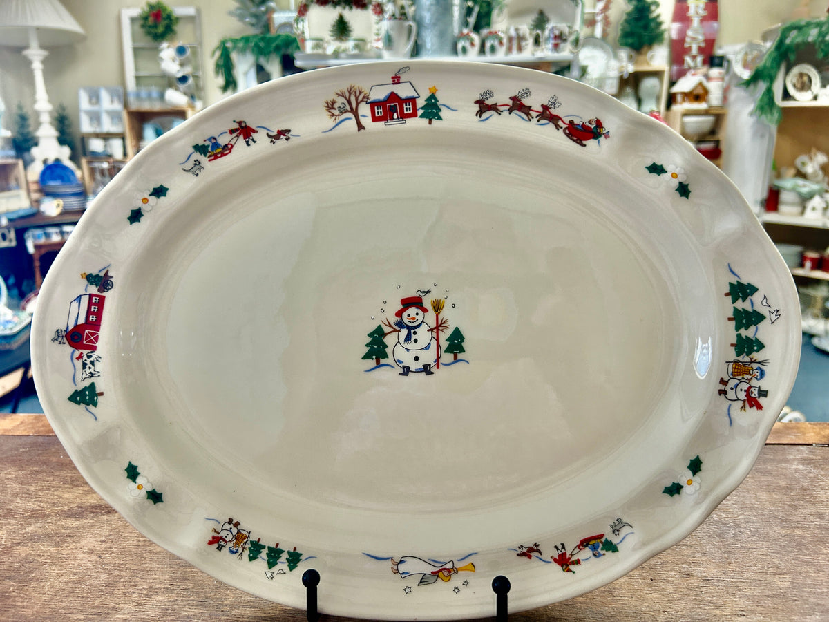 Ceramic serving platter with snowy village border and central snowman illustration