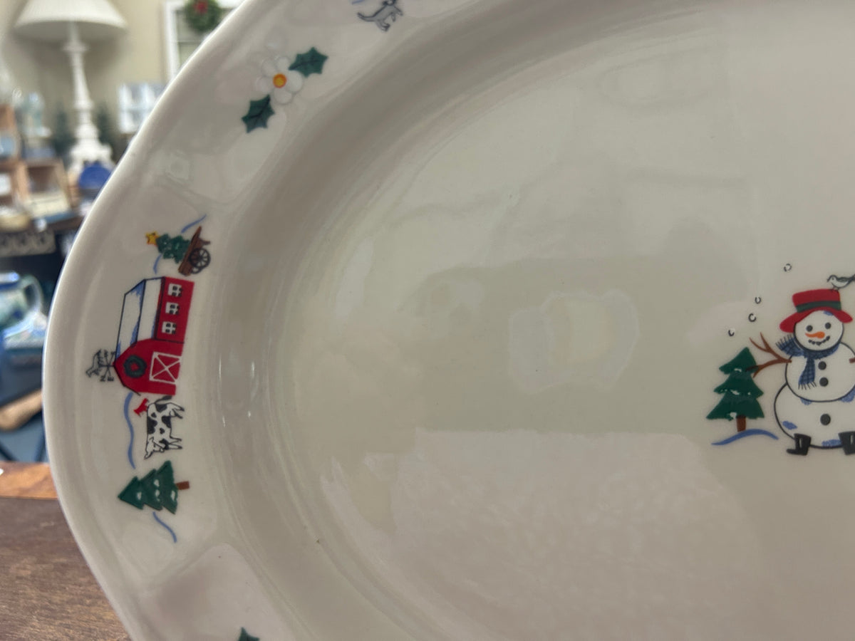 Ceramic oval platter with winter border scenes along the rim and snowman detail