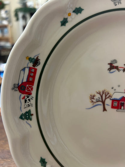 Holiday plate rim detail with red house, sleigh, and green holly on white ceramic