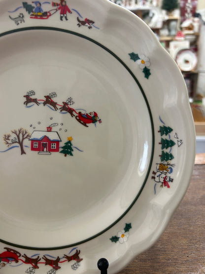 Holiday village plate rim with green holly, red house, and sleigh along curved border