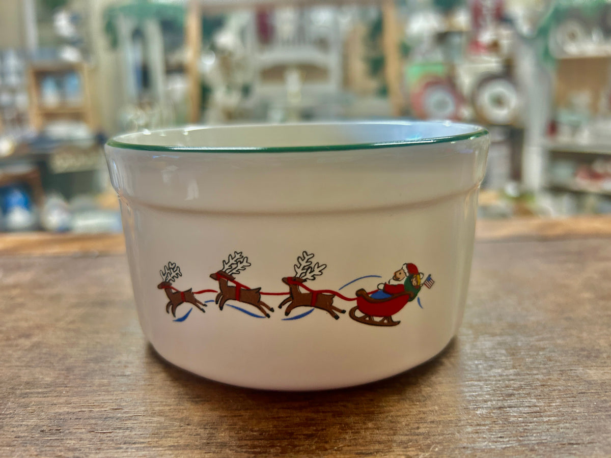 Snow village ceramic bowl with reindeer and Santa sleigh scene, green rim