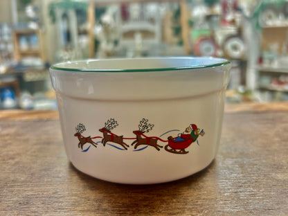 Snow village ceramic bowl with reindeer and Santa sleigh scene, green rim