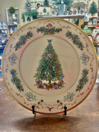 Decorative Christmas plate with central painted evergreen tree and gold rim, floral border