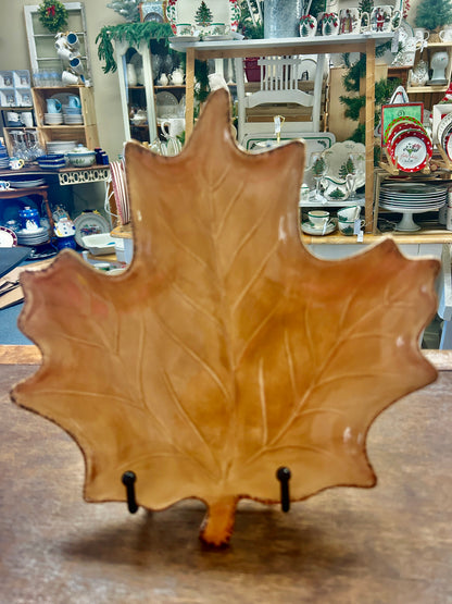Brown leaf-shaped ceramic serving plate with black stand pegs