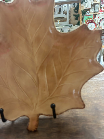 Brown leaf-shaped ceramic plate with embossed leaf pattern, partial view