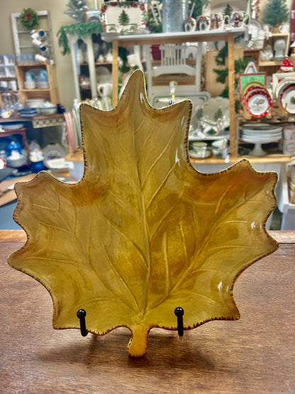 Leaf-shaped ceramic serving plate, gold-green glaze with ridged edges on display stand