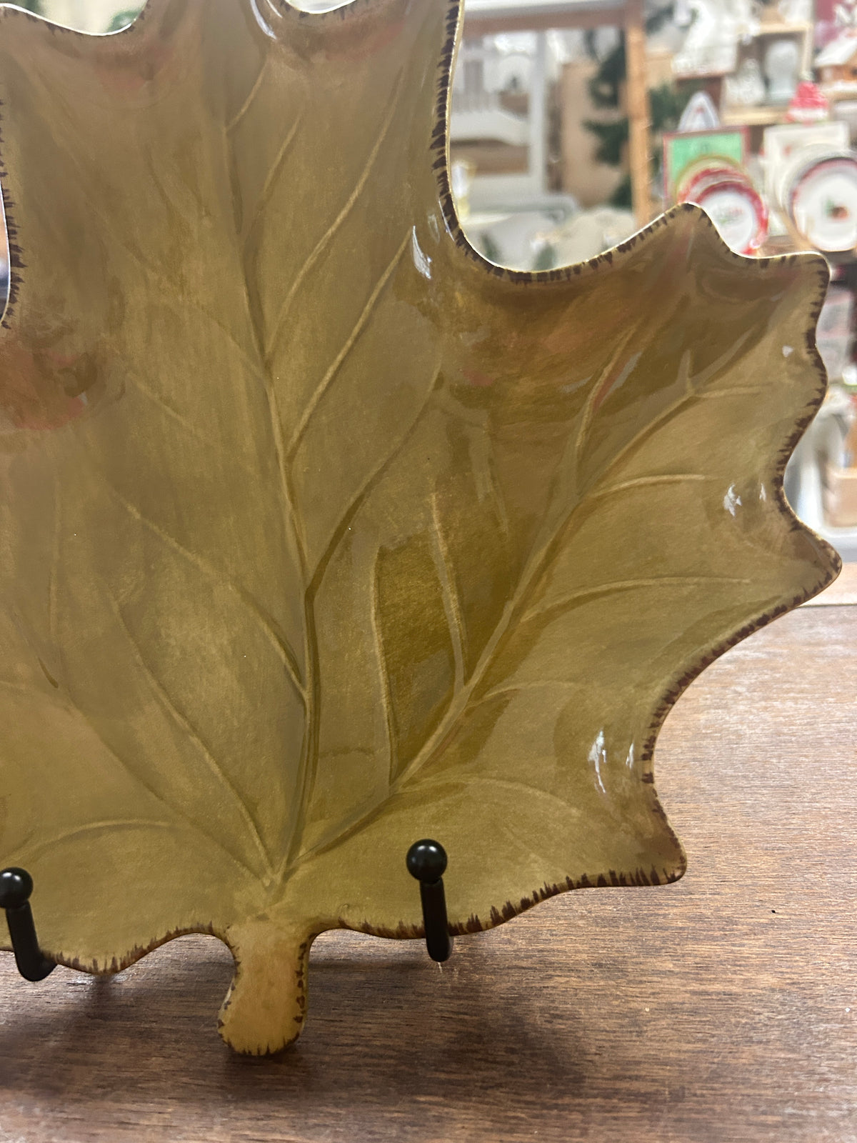 Gold-green leaf-shaped ceramic plate with glossy rim and two metal display hooks