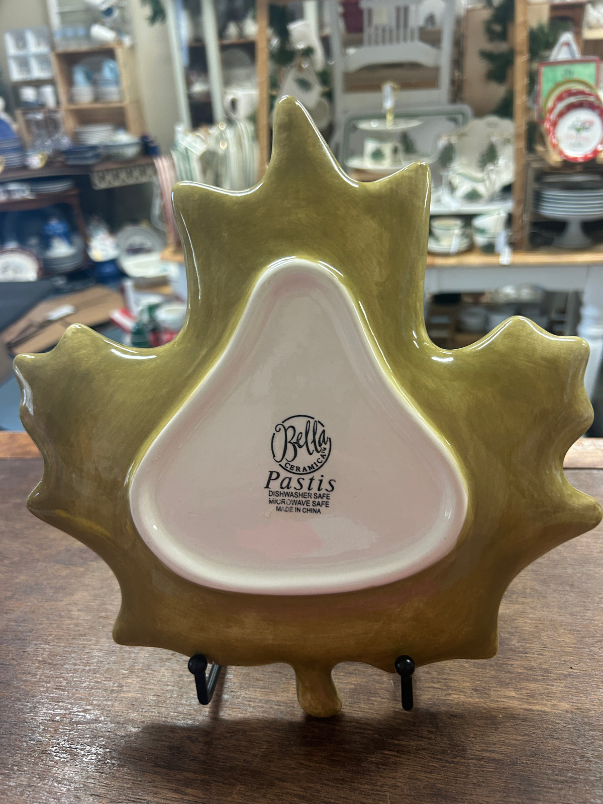Leaf-shaped ceramic serving plate with gold-green rim and white center, Bella Ceramica logo