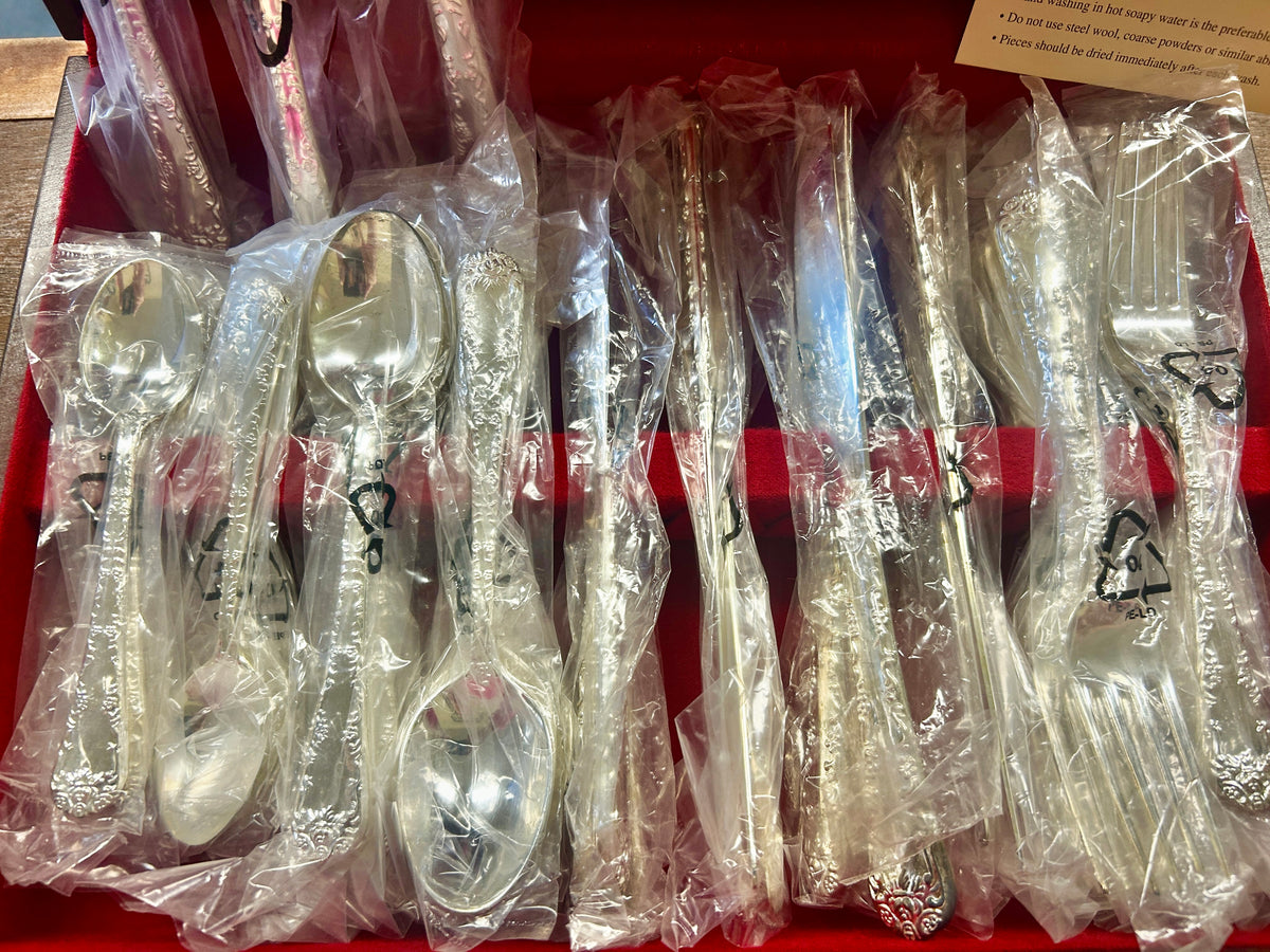 Silverware set with multiple wrapped spoons and forks in the box