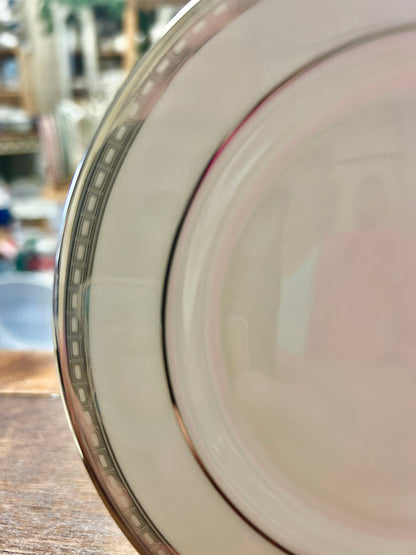 Bread plate rim close-up with silver border, pink trim, and black inner line