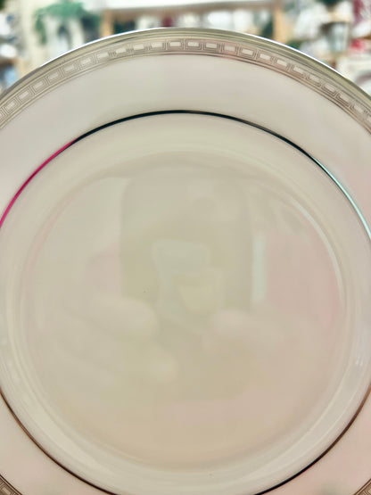 Cream round bread plate with black ring and silver-tone patterned rim