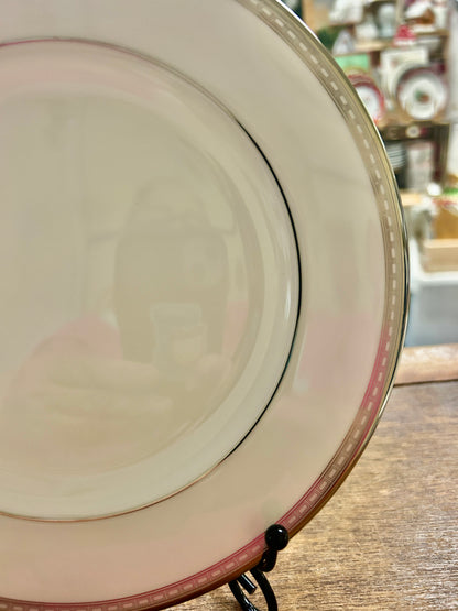 Angle view of cream salad plate with silver rim and red accent line
