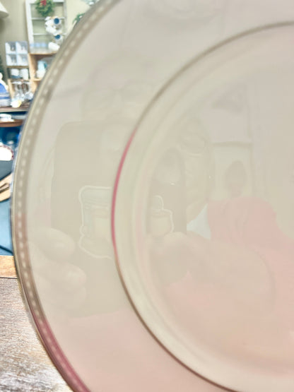 White dinner plate close-up with silver-toned rim and thin pinkish inner ring