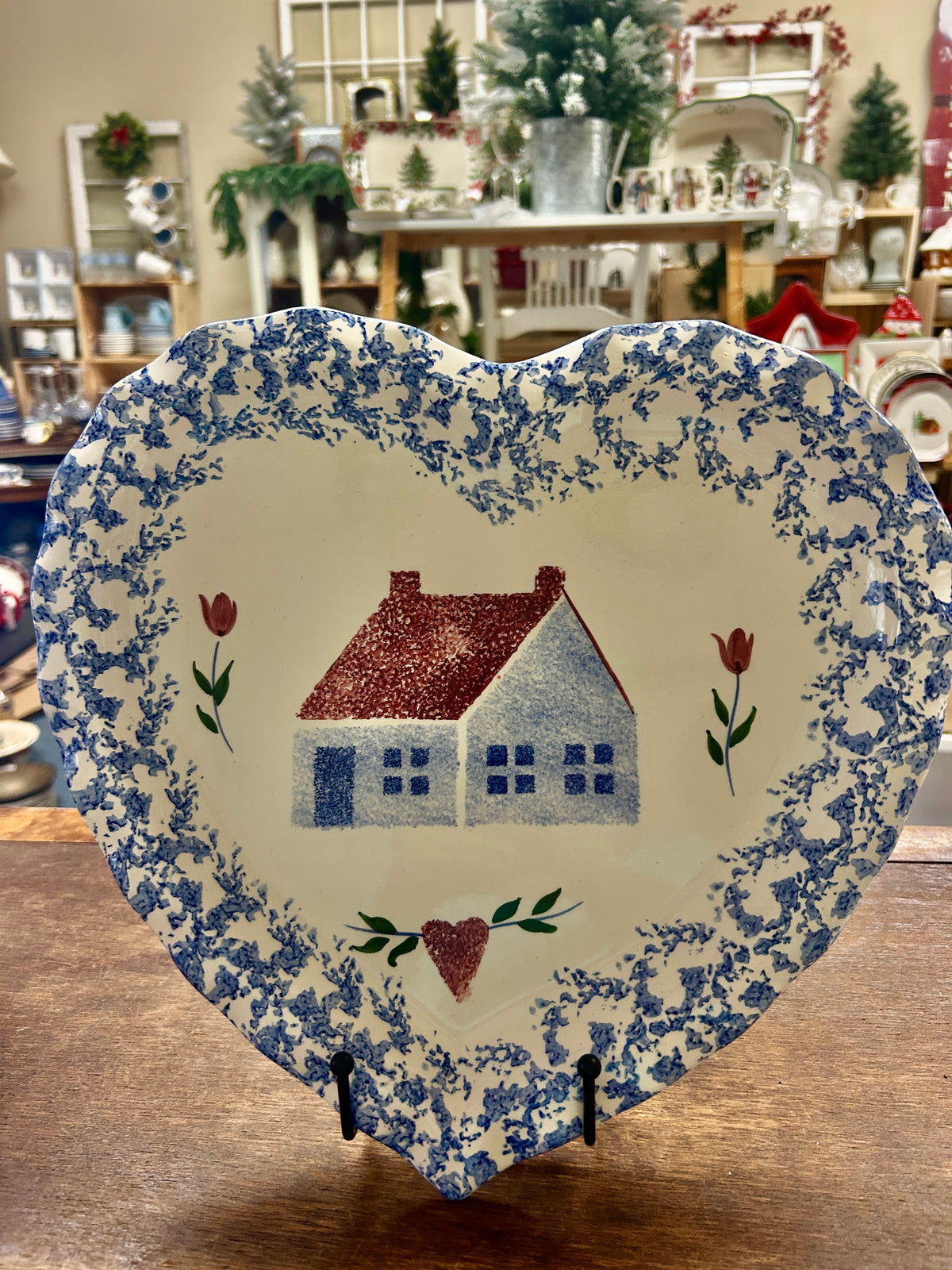 Heart-shaped sponge platter with blue floral-speckle rim and centered red house illustration.