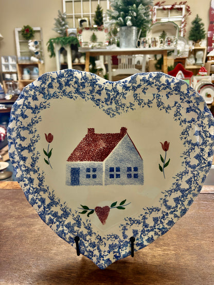 Heart-shaped sponge platter with blue floral-speckle rim and centered red house illustration.