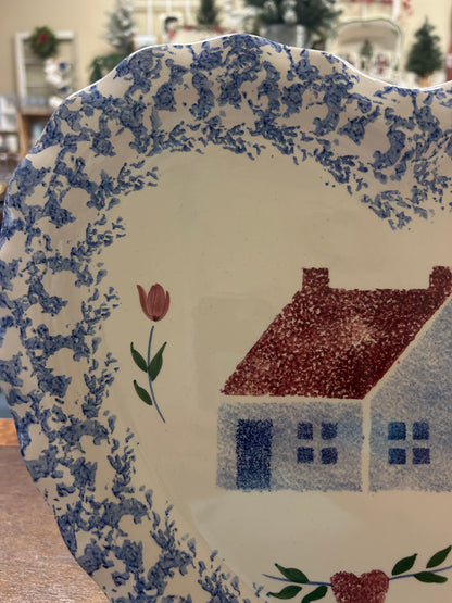 Heart-shaped platter close-up of blue speckled border, tulip stems, and red house.