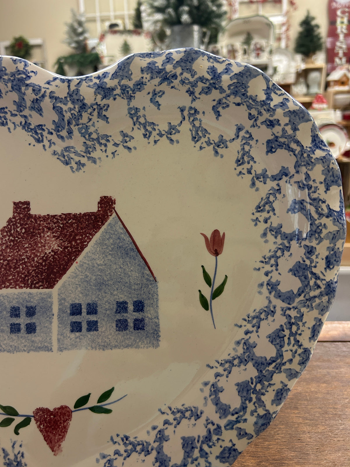 Heart-shaped sponge platter with blue speckled border and red house and tulip design.