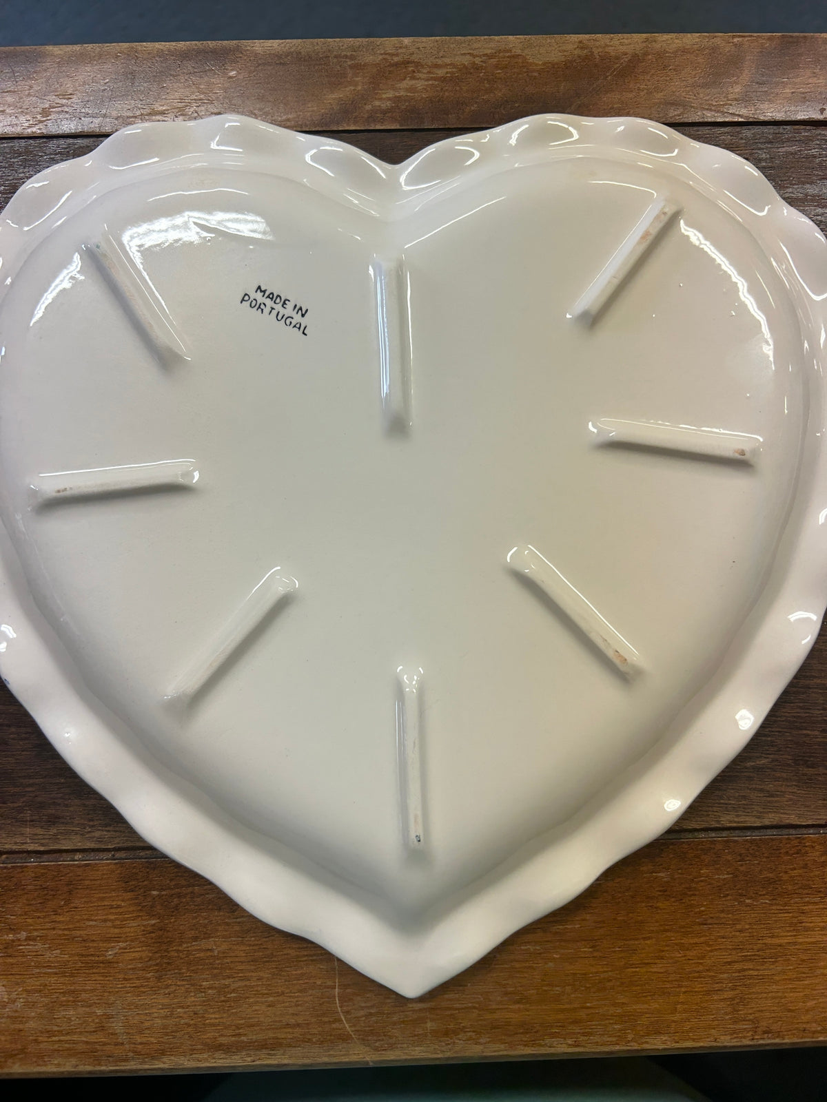 Heart-shaped platter underside, glossy white with stamped made-in-Portugal markings.