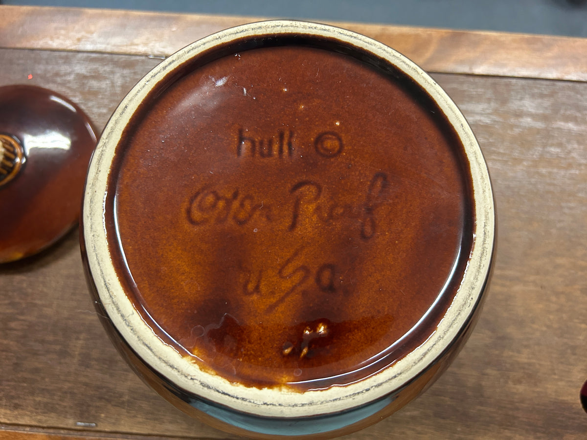 Bottom of brown drip bean pot with “Hull” stamped logo, 7 in
