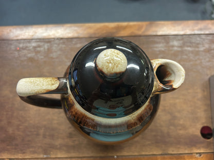 Brown ceramic drip coffee pot lid removed, showing dark interior and knob