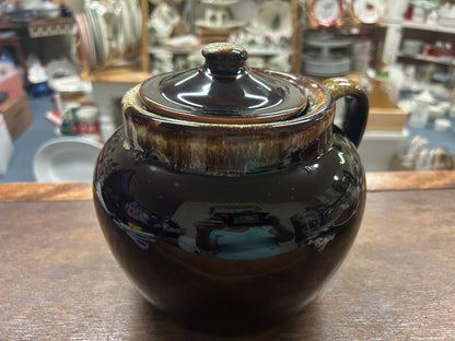 Brown ceramic bean pot with domed lid and gold drip edge, loop side handle.
