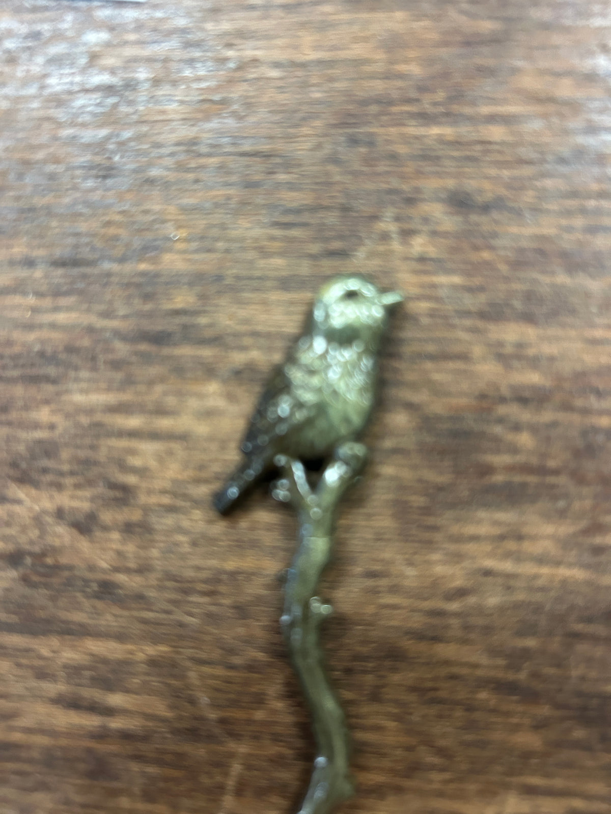 Bronze-toned bird-shaped cocktail fork, close-up of bird figure on handle