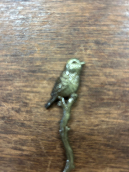 Bronze-toned bird-shaped cocktail fork, close-up of bird figure on handle