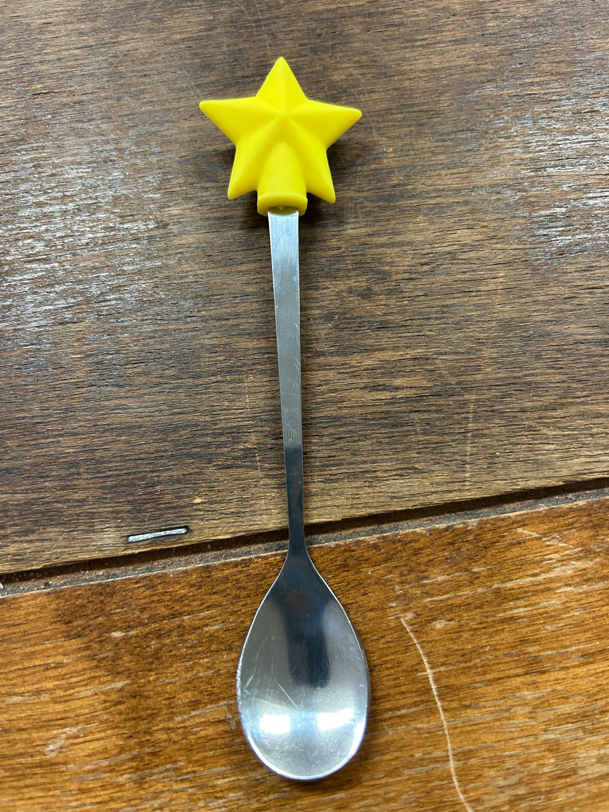 Yellow star-top spoon with silver bowl and long handle