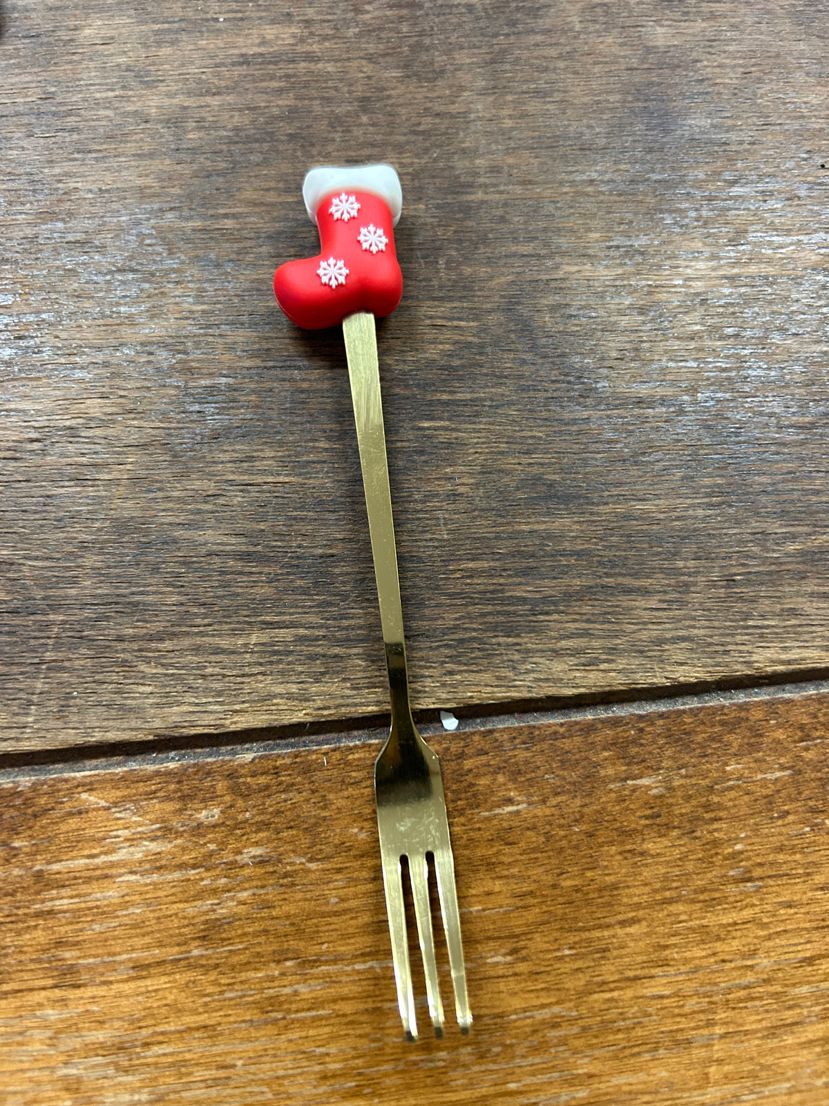 Christmas gold fork with red stocking handle and white snowflake decorations