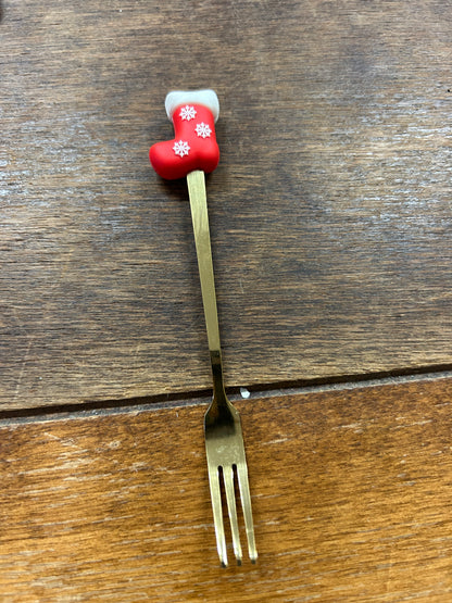 Christmas gold fork with red stocking handle and white snowflake decorations