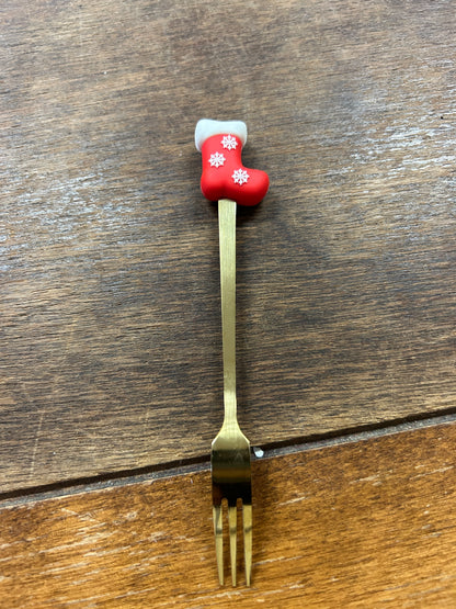 Christmas gold fork with red stocking handle with two white snowflake icons
