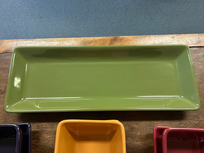 Green rectangular serving tray with partial square dishes in navy, orange, and red