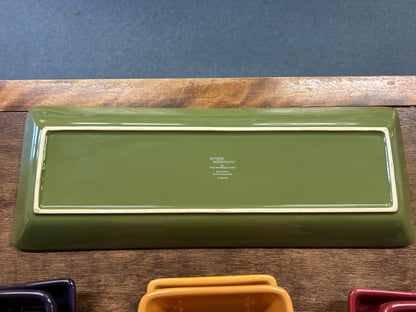 Green rectangular serving tray with small center logo label; corners show glossy rim