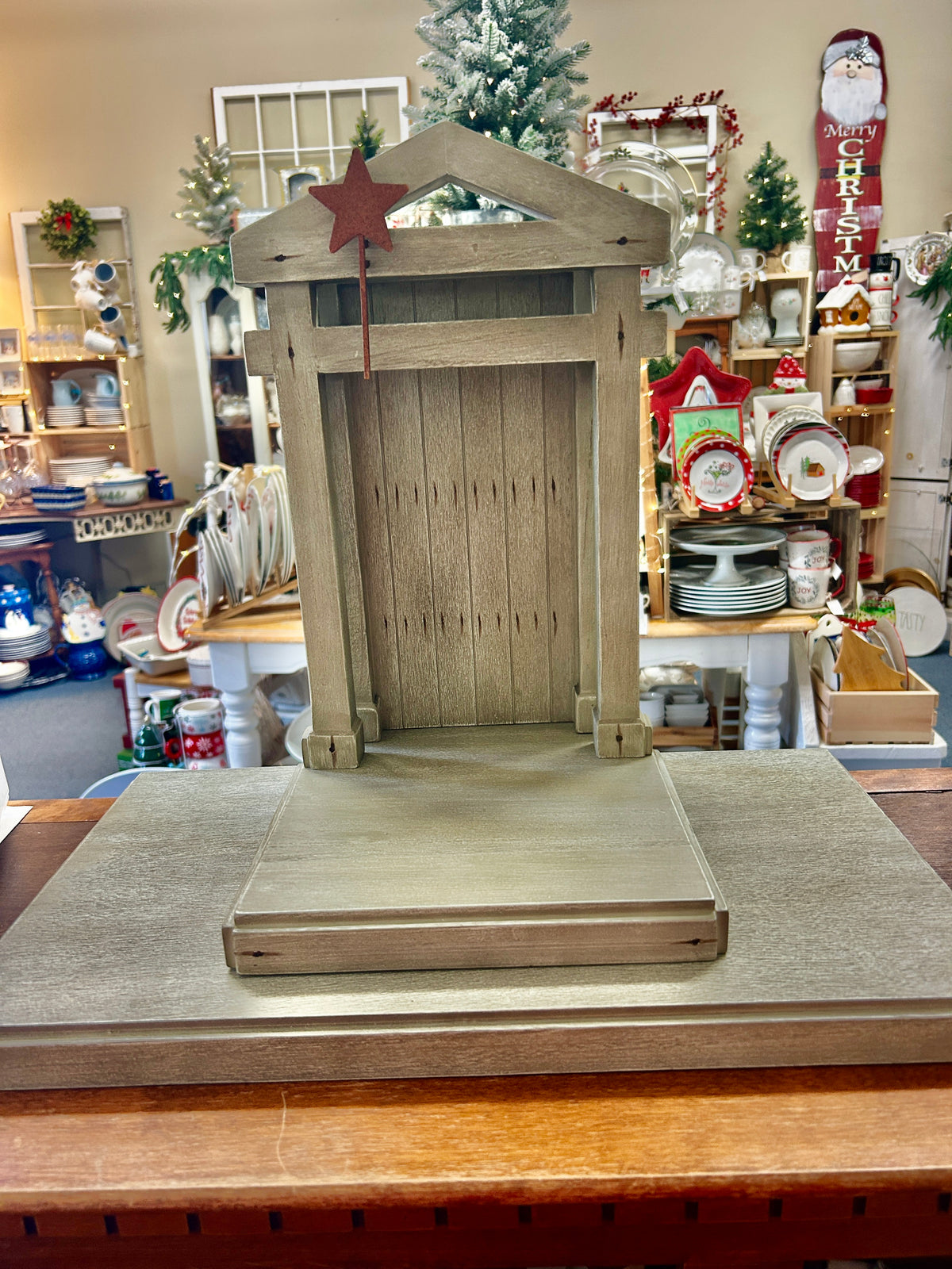Wooden nativity creche base with arched door, roof, and red star finial, 20-inch