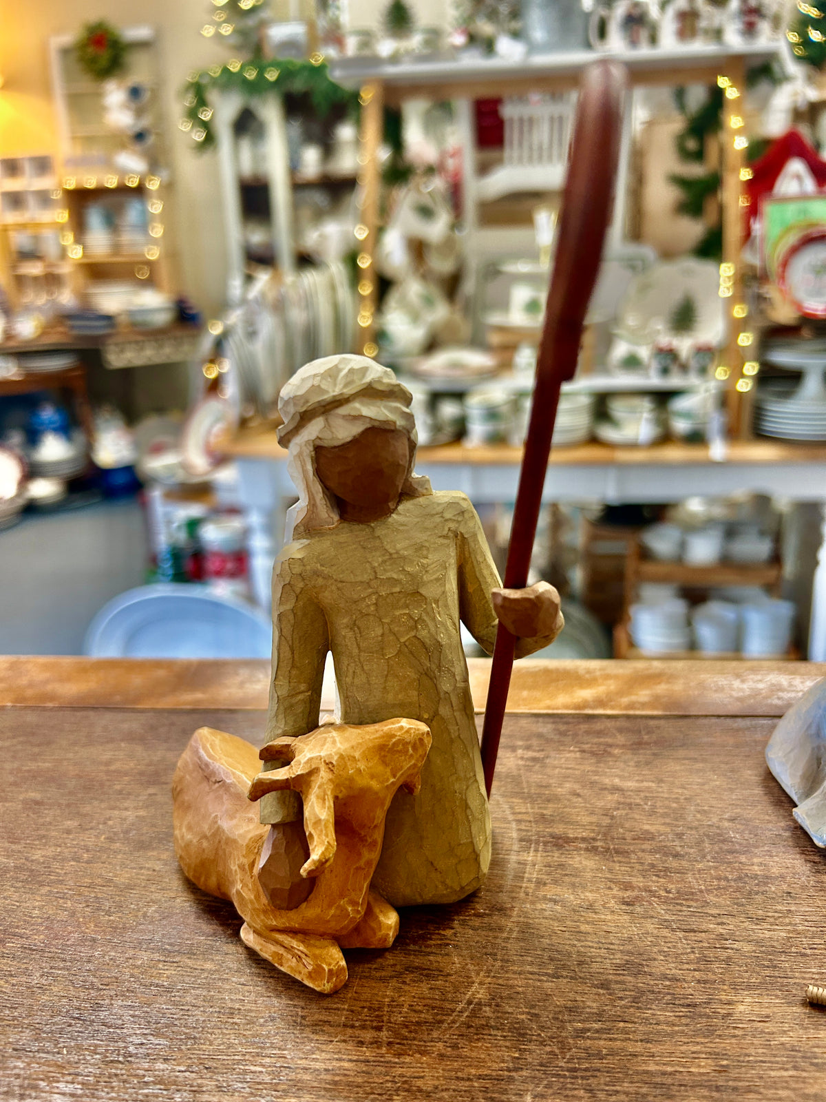 Cream shepherd figurine holding staff with small animal at feet