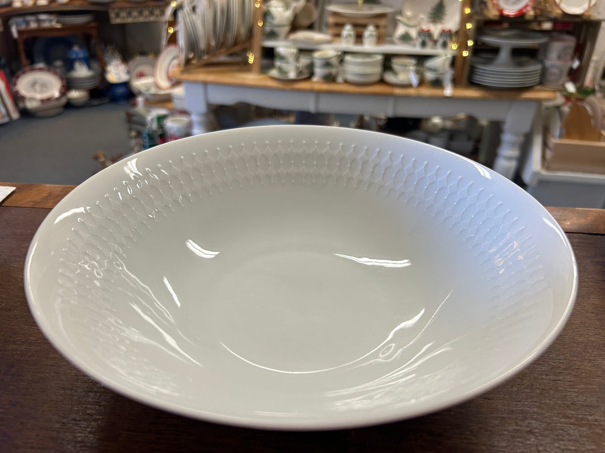 White serving bowl interior with glossy glaze and raised dotted texture around rim