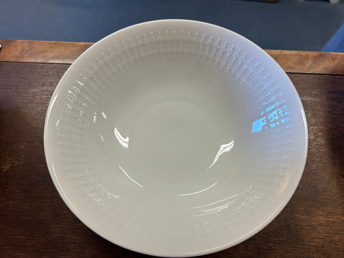White serving bowl with embossed dotted texture and glossy interior, angled view