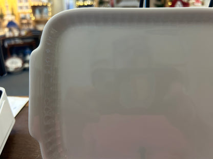 White rectangular ceramic platter close-up, embossed edge detail