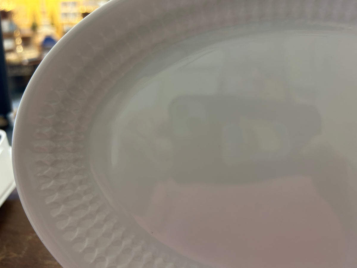 White oval platter rim with embossed texture and scalloped border