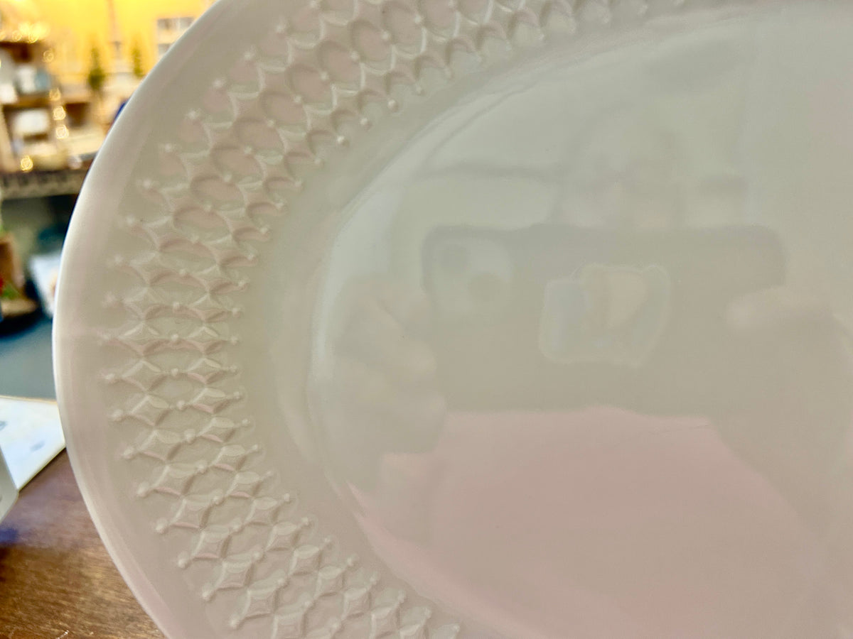 White oval platter with textured raised pattern along the rim